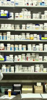 Pharmacist in front of medicine shelf