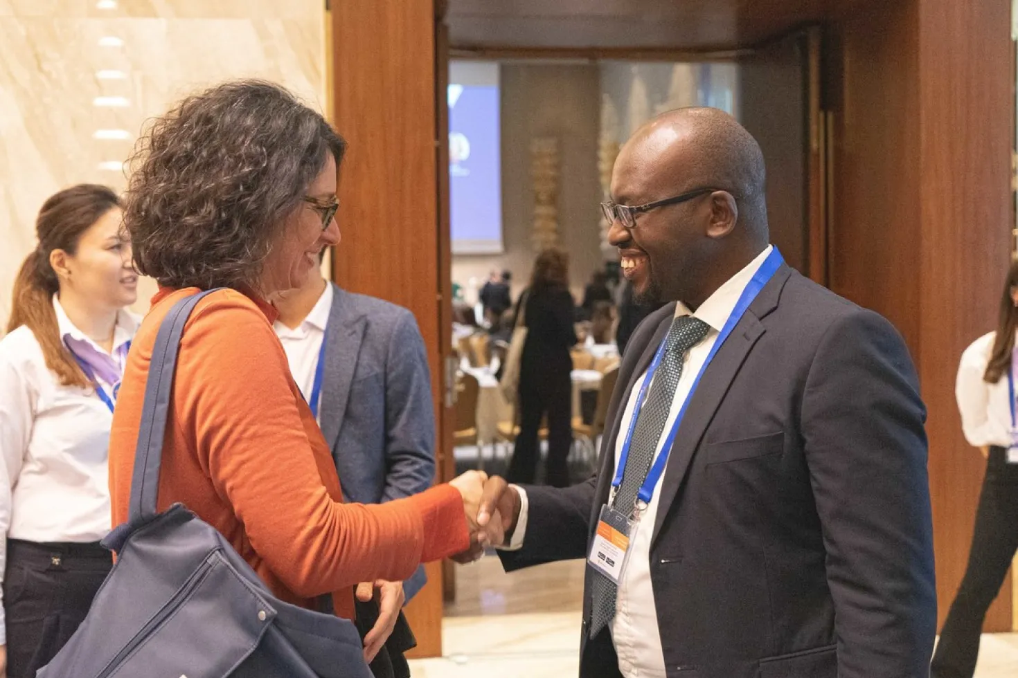 a woman and a man shaking hands at 2019 World Cancer Leaders Summit in Kazakhstan