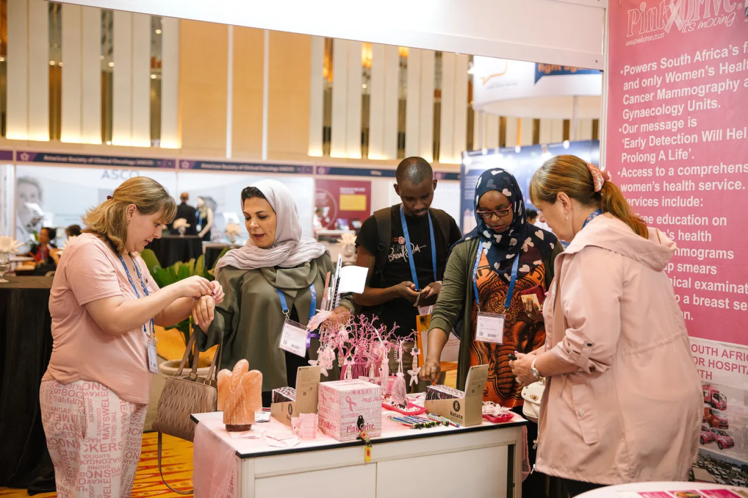 people around a stand selling pink products