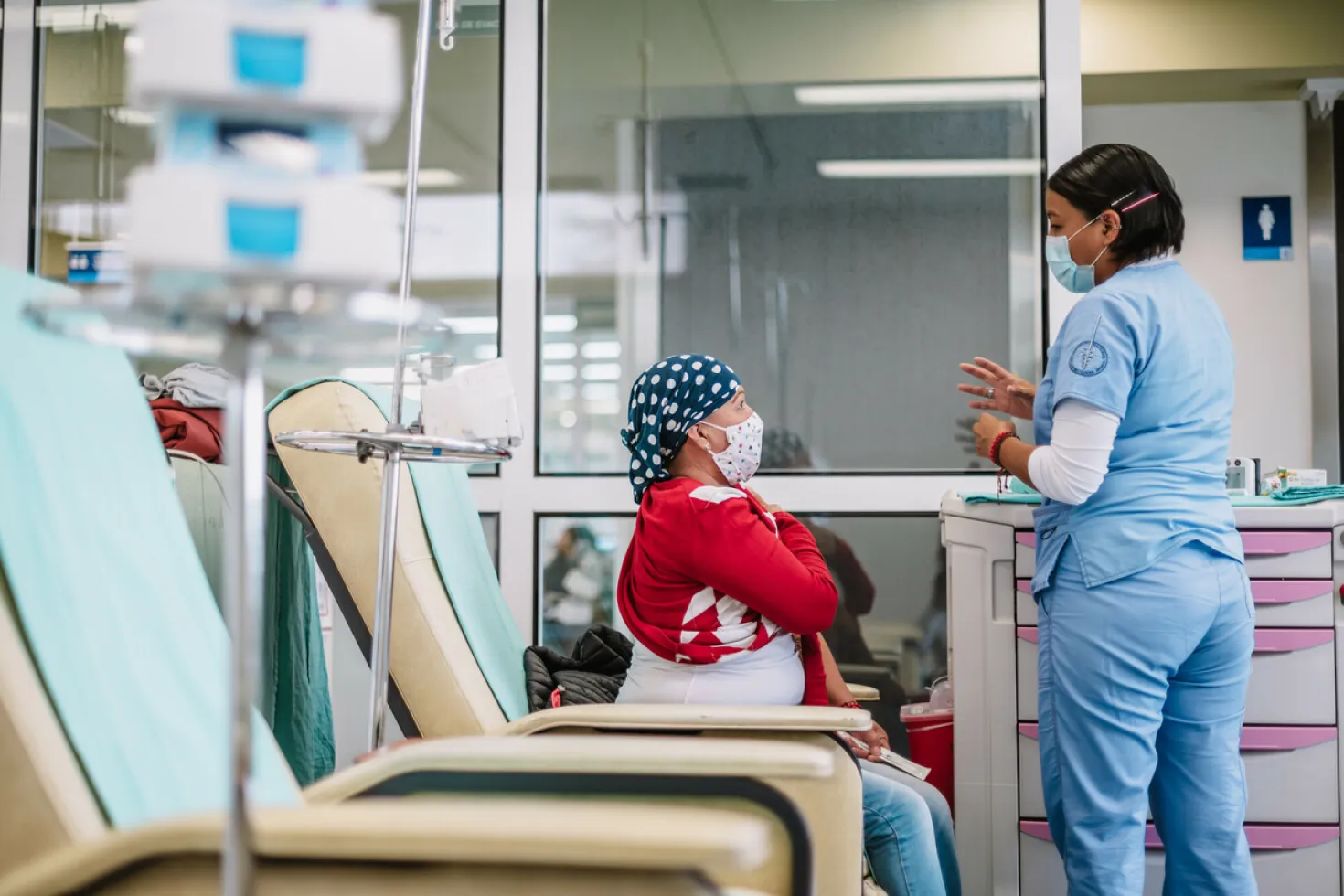 Photographer Adán Jardón offers an intimate look at the life and work of people living with cancer and healthcare professionals at INCAN, Instituto Nacional de Cancerología or National Cancer Institute in Mexico. Caregiver talking to a woman who has just received cancer treatment