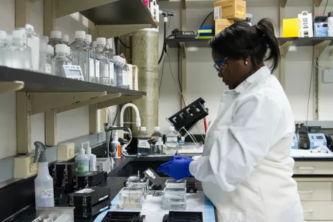 Black woman in lab coat running analyses