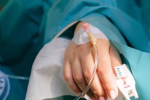 Close up of a hand of a hospital patient receiving IV antibiotics
