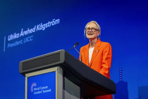 Ulrika Årehed Kågström, President of UICC, in orange suit against branded blue background