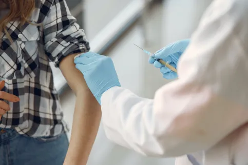 Doctor administrating vaccination to girl