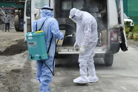 Two medical practioners in personal protective equipment at a makeshift COVID-19 hospital in India.