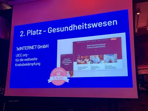 Projected slide showing screenshots of the mobile and desktop versions of the uicc.org website winning 2nd place at the Splash Awards 2023