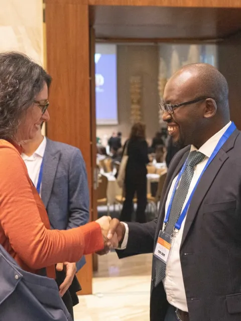 a woman and a man shaking hands at 2019 World Cancer Leaders Summit in Kazakhstan