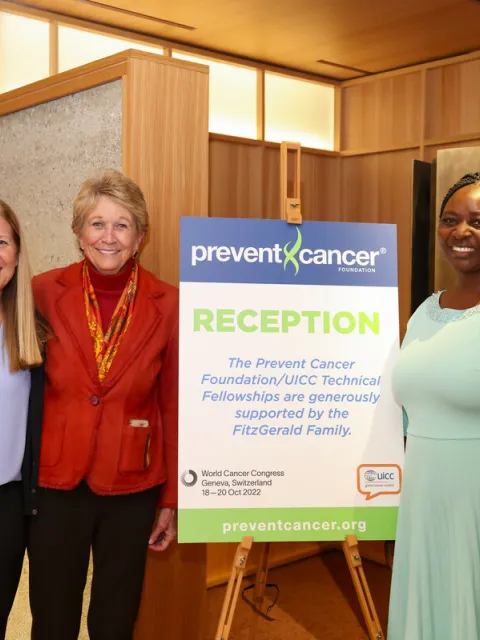 Women posing at the entrance of a conference