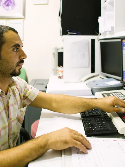 Man at Istanbul University Oncology Institute looking at a computer