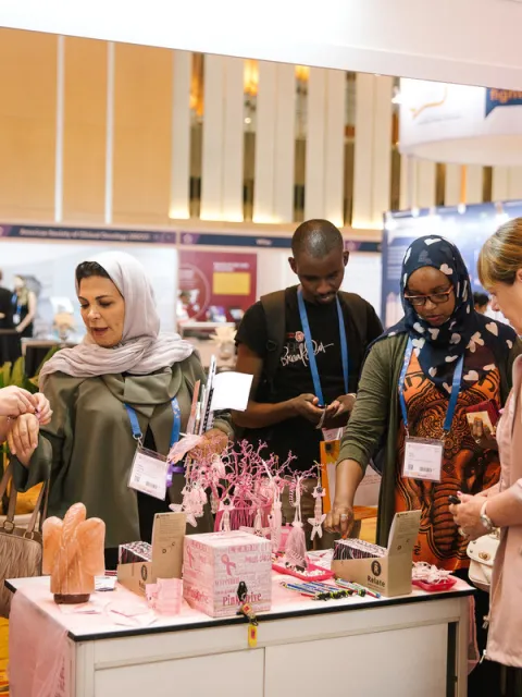 people around a stand selling pink products