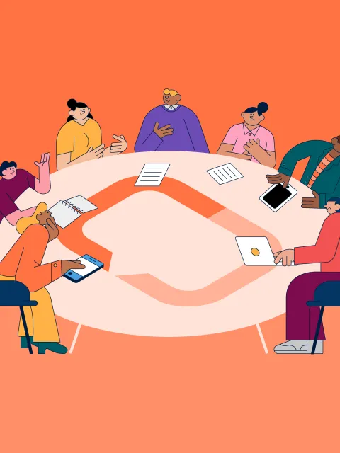 People sitting around a round table adorned with UICC's logo