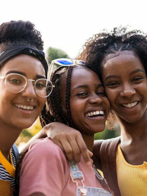 Three young girls hugging and smiling